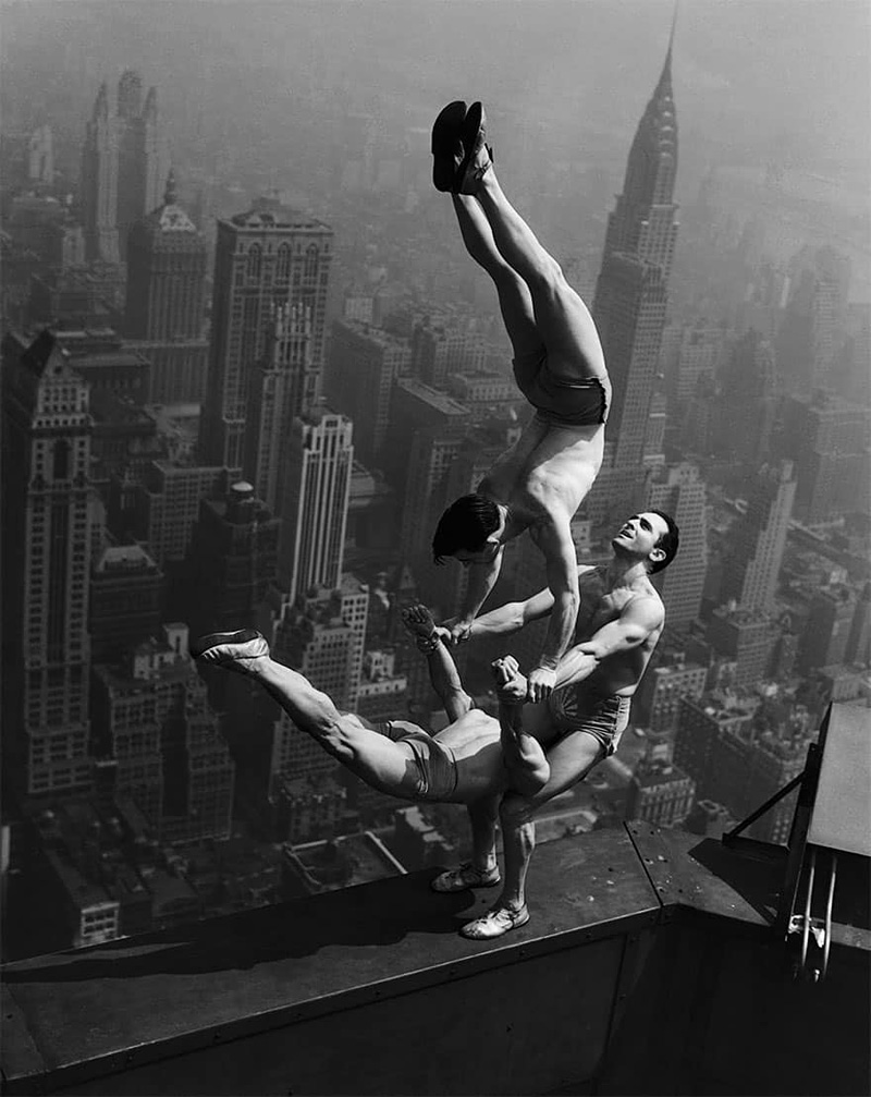 Trois acrobates en équilibre au sommet de l'Empire State Building à New York en 1931